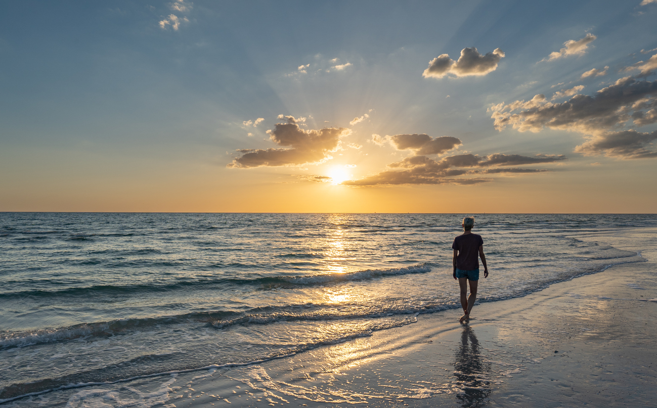 Woman enjoying a vibrant sunset at Treasure Island Beach on the Gulf Coast of Florida USA