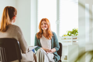 Mature woman smiling while discussing with ocd for TMS