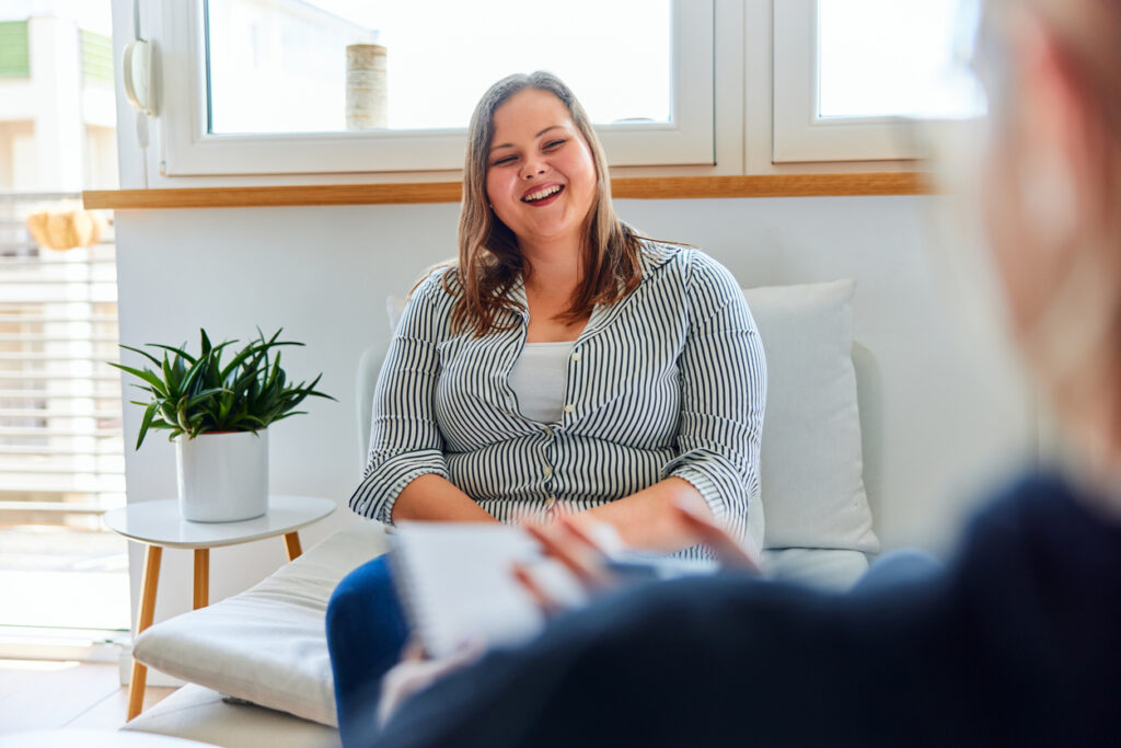 A happy overweight woman is satisfied with her progress, and talking with her psychologist.