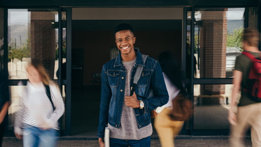 a student standing in a doorway and smiling
