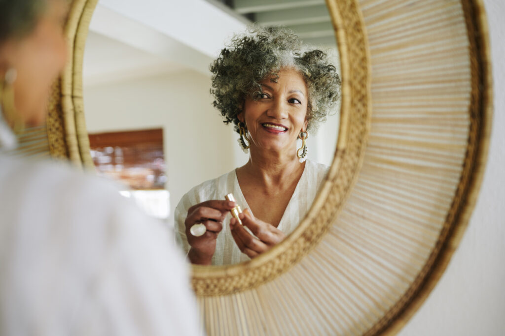 a woman smiling and looking into the mirror, seeing herself