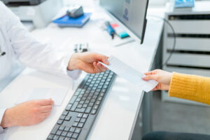 A provider handing someone a slip of paper