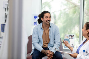 male patient sitting in a chair listening to a doctor